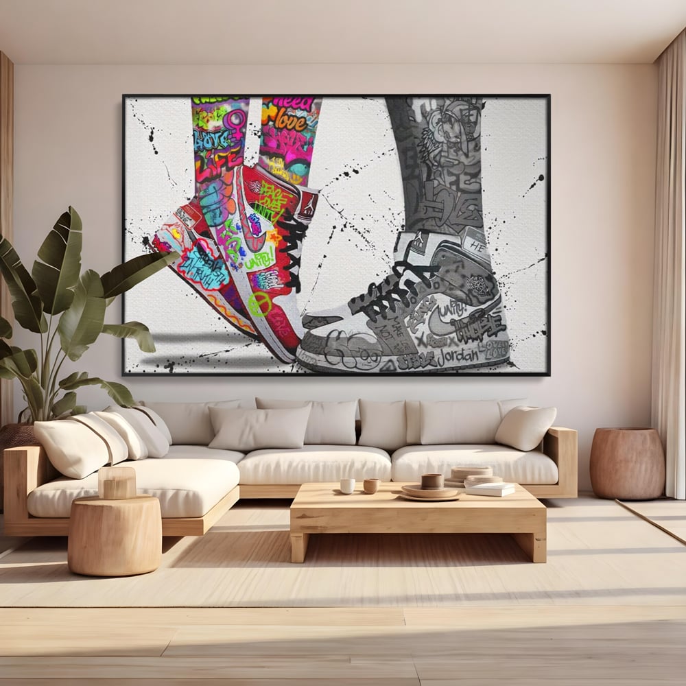Tablou canvas cu tablou canvas cu adidasi graffiti si picioare, in rama de aluminiu negru, pe perete intr-un living